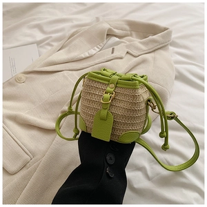 Détail du sac seau en paille pour enfants avec bordure en cuir vert et cordon