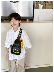 Close-up of a child black chest bag with a yellow smiley face and adjustable strap