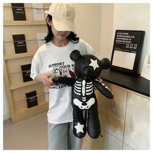 Detail shot of a punk black leather teddy bear with skeletal patterns and star patches