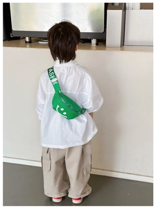 Detail of neon green kids waist bag with smiley face and FASHION lettered strap
