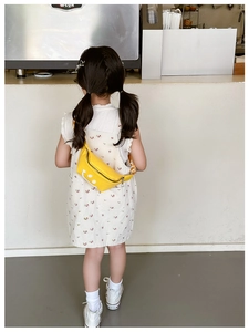 Close-up of yellow kids fanny pack featuring a cartoon smiley face and adjustable strap