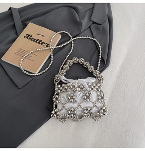 Detail of silver beaded hollow shoulder bag with a white drawstring inner pouch