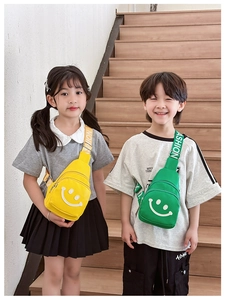 Detail of yellow and green mini chest bags with smiley faces and fashion logo straps