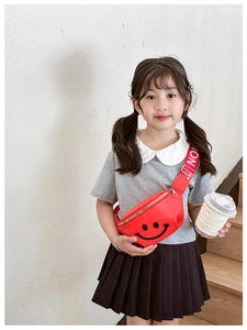 Close-up of a red smiley face waist bag for kids with adjustable logo strap details