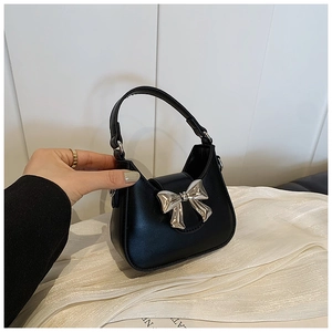 Détails du sac croissant noir avec nœud en métal argenté et texture en cuir raffiné