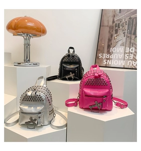 Three mini rivet backpacks in silver, black and pink with metal planet pendants