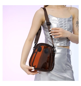 Close-up of a stylish transparent brown jelly crossbody bag with an adjustable strap