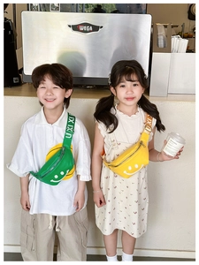 Detail view of kids chest bags in bright yellow and green featuring a white smiley face