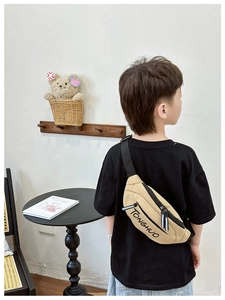 Detailed close-up of khaki canvas kids chest bag with TONGHUO letter print and zippers