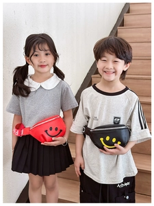 Detail view of red and black kids waist bags with iconic yellow smiley face pattern