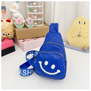 Detail of royal blue kids crossbody bag with white smiley face and fashion strap