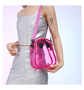 Detail of pink transparent PVC crossbody bag with cartoon eyes and wide fabric strap