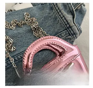 Close-up of pink laser mirror finish mini bag with silver bow and chain strap