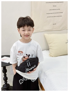 Kids black nylon chest bag with white TONGHUO lettering worn by a child in home setting