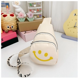 Detailed view of beige mini crossbody bag with yellow smiley face and fashion strap