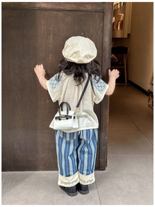 Detailed back view of toddler girls' vintage floral top and blue striped wide-leg trousers