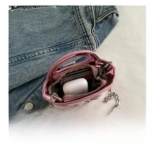 Internal capacity of girls' pink metallic leather bag showing space for earbuds and cards
