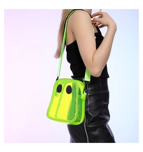 Detail of neon green transparent PVC crossbody bag with a cartoon eye design for beach vacations