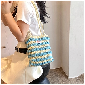 Détail du sac bandoulière rayé crocheté main avec étiquette Sweet Cherry en bleu et beige