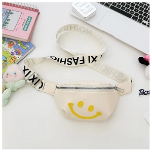 Detail of off-white canvas kids fanny pack with yellow smiley face and XI FASHION strap
