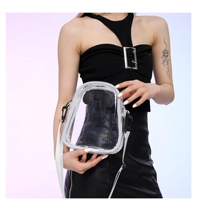Close-up of a transparent PVC mini crossbody bag with white stitching and cartoon details