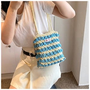 Détail du sac bandoulière tricoté main à rayures bleues et blanches et texture en relief