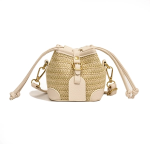Fashionable bohemian straw bucket bag with cream faux leather trim and golden metal hardware