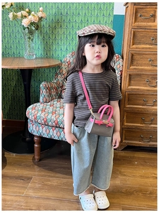 Detailed view of girls' retro mini shoulder bag paired with outfit and beret