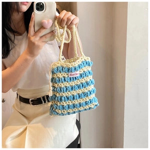 Gros plan sur la texture au crochet et l'étiquette Sweet Cherry du sac rayé