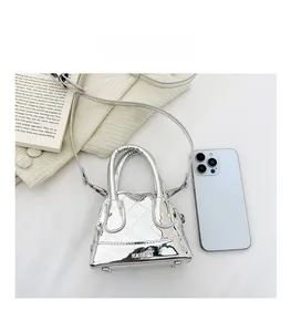 Mini sac argenté matelassé avec logo de marque présenté à côté d'un smartphone moderne