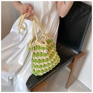Détail du sac seau tricoté main vert et crème avec cordon et étiquette Sweet