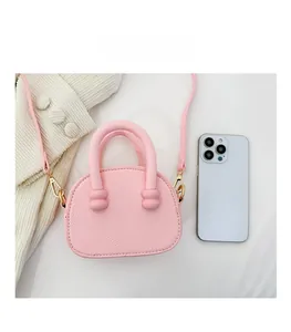 Mini borsa rosa a tracolla con trama a grana e un telefono come riferimento misura