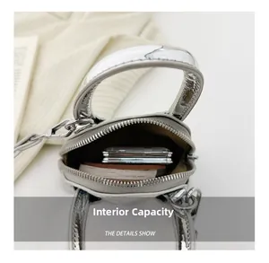 Mini sac à main argenté effet miroir montrant le rangement interne pour cartes et livres