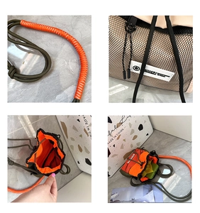 Detail of army green nylon drawstring bag with orange lining and woven shoulder strap