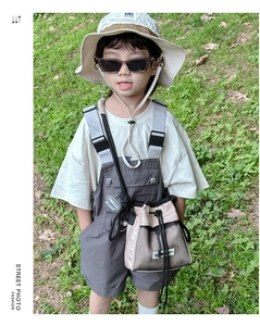 Close-up of kids stylish drawstring bucket bag in pink beige mesh on a model