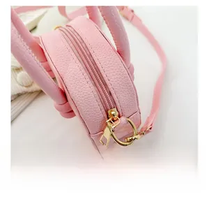 Dettaglio della cerniera dorata e pelle rosa martellata su borsa per bambini
