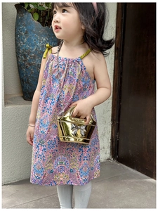 Detail of a golden laser finish mini bag with silver bow and delicate chain strap