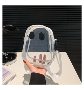 Close-up of transparent PVC kids crossbody bag with cute ghost face and white woven strap