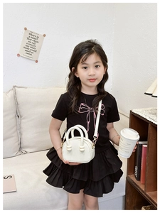 Dettaglio borsa a tracolla bianca per bambini con hardware dorato e trama litchi