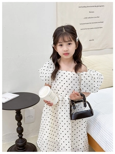 Close-up of girls white polka dot dress with stylish puff sleeves and square neckline