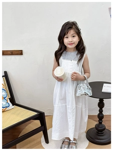 Détail d'une robe blanche sans manches en dentelle pour enfants en coton-lin au style rétro