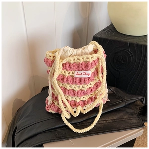 Gros plan du sac seau au crochet rose et beige avec étiquette Sweet Cherry et cordon