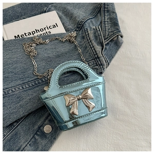 Detail of laser light blue mini bag featuring a silver bow and metal chain strap
