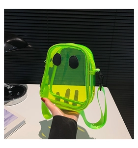 Detail view of neon green transparent PVC mini crossbody bag with cute face design
