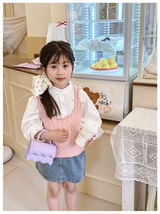 Detail of a purple mini crossbody bag with wavy flap design on a stylish girl outfit