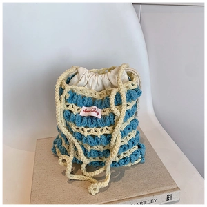Détail du sac seau au crochet rayé bleu et crème avec une texture en relief