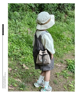 Detailed view of kids outdoor drawstring crossbody bag paired with fisherman hat and outfit