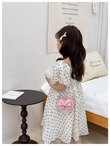 Détail du sac à bandoulière rose en forme de cœur pour enfant avec nœud et chaîne