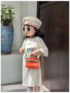 Detail of orange litchi leather mini bag with grey handle and metal turn lock