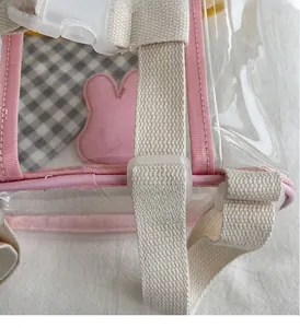 Détail du sac transparent en PVC rose avec sangle réglable et garnitures métalliques